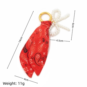 Detailed view of red paisley scarf keychain with pearls and dimensions labeling