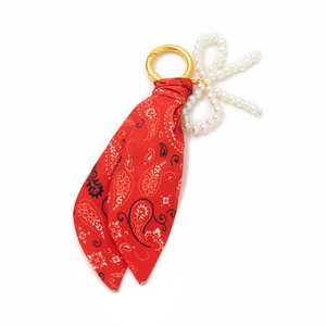 Fashionable red paisley fabric bag charm with golden metal clasp and pearl bow detail