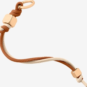 Detail of woven leather keychain with cream and brown cords and gold hexagonal metal accents