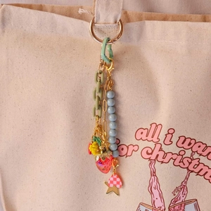 Colorful fashion keychain with heart ring and star charms on a canvas bag