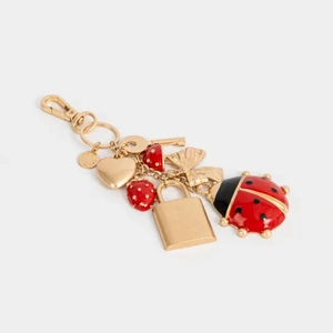 Détail du porte-clés coccinelle et fraise avec breloques dorées et émail rouge