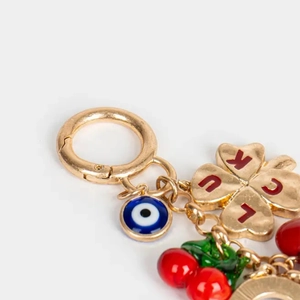 Détail du porte-clés avec trèfle à quatre feuilles, œil grec et pendentif cerise rouge