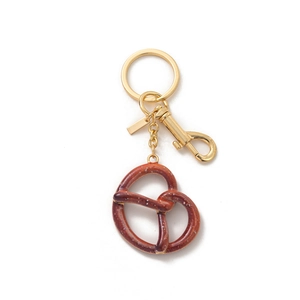Detailed macro view of a pretzel keychain with gold hardware and white sea salt texture