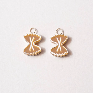 Detailed macro view of 18K gold-plated Farfalle pasta shaped acrylic jewelry pendants
