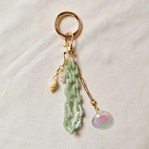 Detail of DIY ocean keychain with sea shell, pearl, and light green acrylic link chain