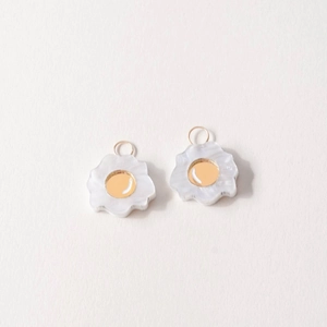 Macro shot of 18K gold plated flower pendants with white pearlescent petals for DIY jewelry
