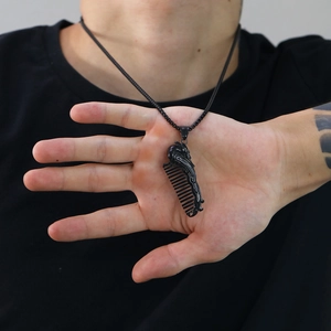 Dettaglio di una collana a pettine nero opaco con pendente a forma di drago scolpito
