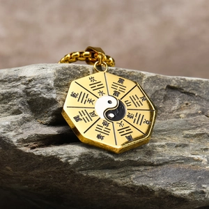 Detalle macro del colgante Bagua dorado con centro de Tai Chi sobre piedra natural