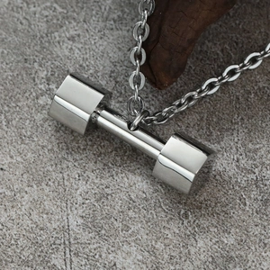 Silver dumbbell pendant necklace with O-chain for fitness lovers on stone background