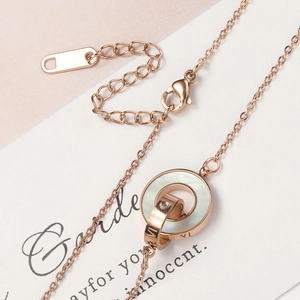 Halskette in Roségold mit römischen Ziffern, Doppelring, weißer Muschel und Kristall