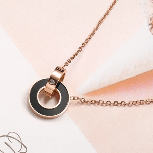 Nahaufnahme der Roségold-Halskette mit römischen Ziffern und schwarzem Emaille-Ring