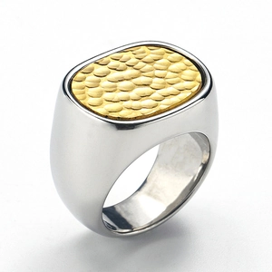 Detailansicht eines zweifarbigen Siegelrings mit goldener Hammerschlag-Textur auf Stahl