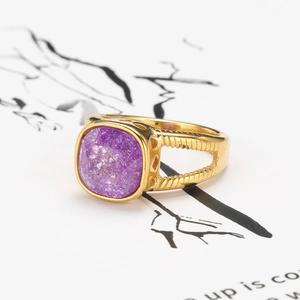 Bague vintage dorée ajourée avec pierre naturelle violette carrée sur fond blanc
