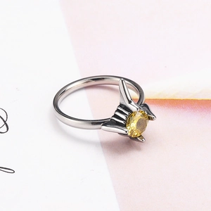 Dettaglio di un anello a punta argento con una pietra di cristallo rotonda giallo vivace