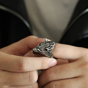 Close-up of a men's Viking wolf head ring in vintage silver finish on a model's finger