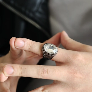 Nahaufnahme eines Vintage-Edelstahlrings mit großem ovalem Schmuckstein und strukturierter Basis