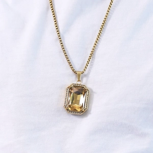 Detail of square champagne gemstone pendant with gold-plated box chain and zircon halo