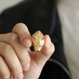 Macro shot of gold viking wolf head ring with detailed engraving and punk aesthetic