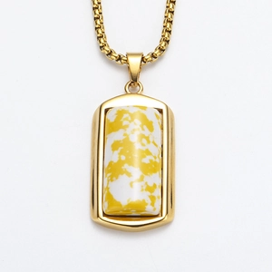 Detail van een rechthoekige gouden hanger met gele marmerstructuur en box ketting