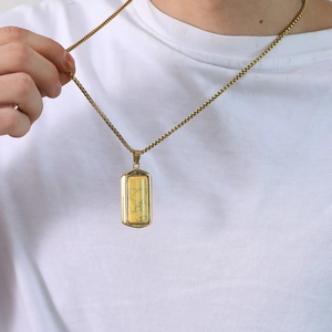Detail van de gouden boxketting met een rechthoekige hanger van turquoise-stijl steen