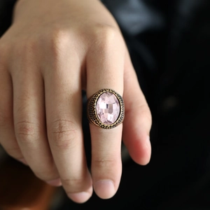 Detail eines Vintage-Bronze-Rings mit großem ovalem rosa Edelstein und Texturen