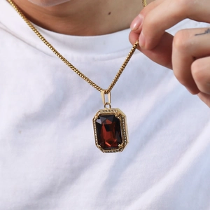 Close-up of a rectangular red gemstone pendant with white zircon bezel on a box chain