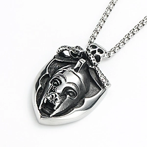 Detail of vintage stainless steel shield pendant with Spartan helmet and skull reliefs