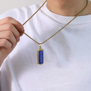 Detailopname van lange gouden titanium hanger voor heren met diepblauwe steeninleg
