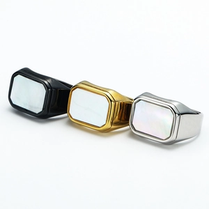 Detailed view of three square signet rings in black, gold, and silver with mother of pearl inlay