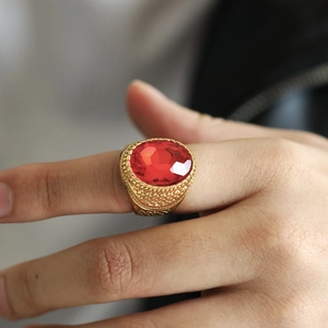 Detail eines vergoldeten Siegelrings mit ovalem rotem Edelstein und Rautenmuster