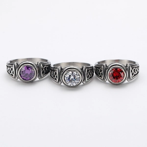 Macro detail of retro titanium steel rings featuring celtic knot carvings and colorful gems