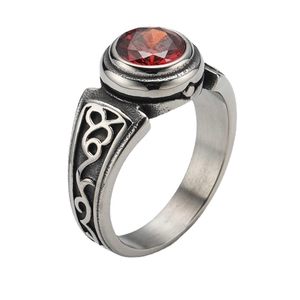 Detail of red faceted gemstone and vintage vine relief on matte titanium steel ring