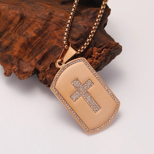 Detail eines roségoldenen Dog-Tag-Anhängers mit Kristallkreuz und Box-Kette