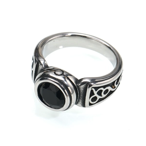 Macro detail of vintage titanium steel ring with round black gemstone and Celtic patterns