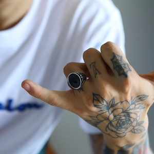 Dettaglio dell'anello punk retrò in acciaio al titanio con onice nera e rilievi incisi