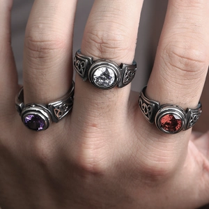 Detailed macro view of vintage rings with inlaid purple, white and red faceted gemstones