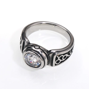 Macro detail of retro stainless steel ring with round gemstone and geometric pattern