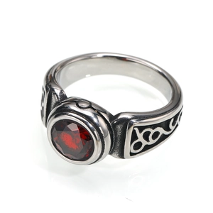 Close-up of retro titanium steel ring with a red gemstone and vintage vine engraving