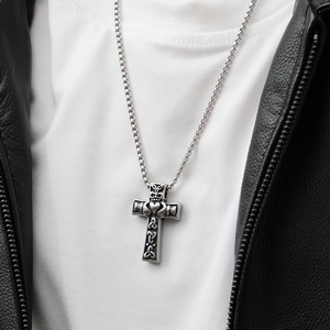 Dettaglio di una collana a croce celtica con cuore Claddagh e motivo a corona