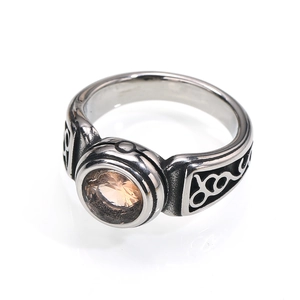 Detail of vintage steel ring featuring a large champagne gemstone and ornate carvings