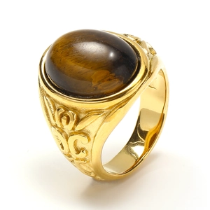 Dettaglio di un anello vintage dorato con occhio di tigre e motivi in rilievo incisi