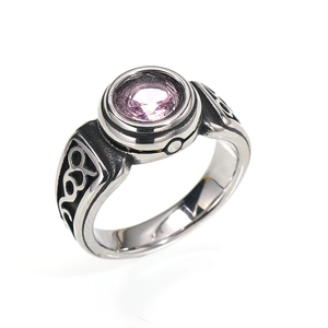 Macro shot of retro steel ring featuring pink gemstone and hollow wave patterns