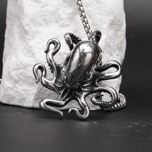 Detailed close-up of retro silver octopus pendant with intricate textures on white stone