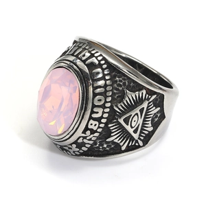 Detalle de anillo punk retro con gema rosa y grabado del ojo Illuminati en acero de titanio