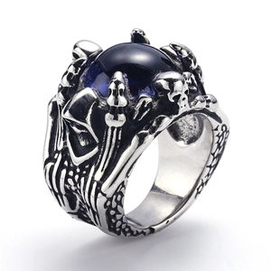 Detailed view of gothic punk ring featuring a blue eye orb and carved skeleton motifs