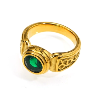 Detail of vintage gold titanium steel ring with a round green gemstone and Celtic carving