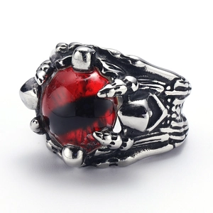 Macro detail of gothic dragon claw ring featuring a mystical red eye stone setting