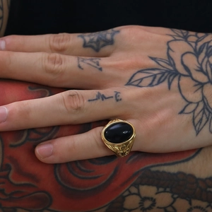 Dettaglio dell'anello da uomo punk retrò in oro con onice nero e rilievi incisi