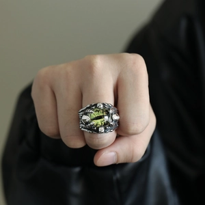 Macro shot of punk gothic dragon eye ring featuring realistic green pupil and silver scales