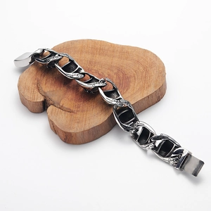 Dettaglio di un bracciale punk vintage con motivi floreali incisi su acciaio